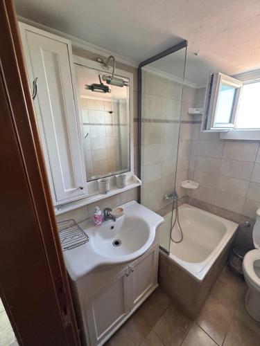 a bathroom with a sink and a tub and a toilet at Danai Nefeli Apartment in Siviri
