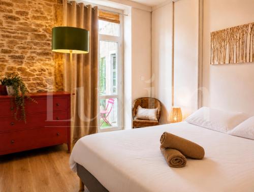 a bedroom with a bed and a chair and a window at Le Cocon de la Presqu'île in Lyon