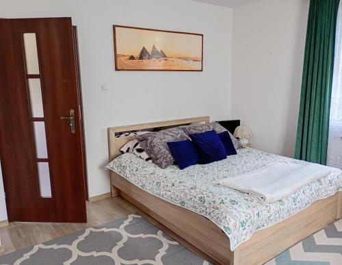 a bedroom with a bed with blue pillows at Noclegi u Franciszka in Trzebiesza
