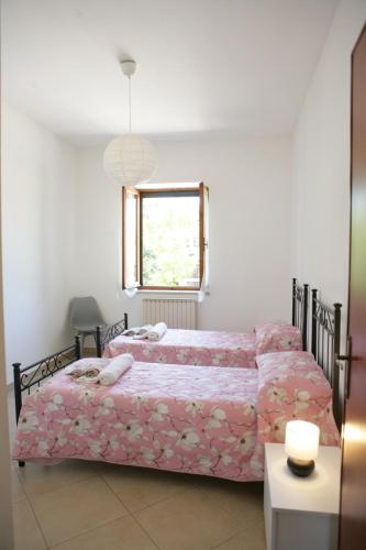 a bedroom with two beds and a window at Casa di Nonna Angela in Guadamello