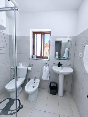 a white bathroom with a toilet and a sink at Vangert Apartment in Berat