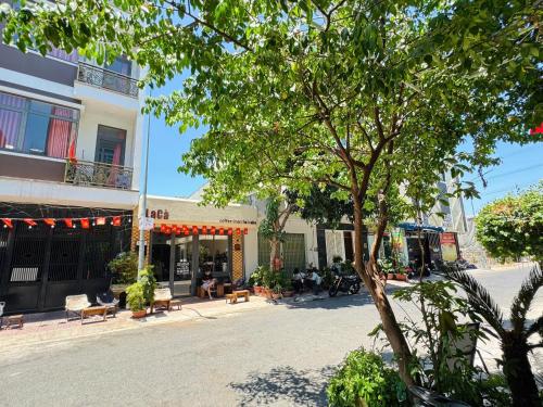a building with a tree in front of a street at Nhà nghỉ B48 in Cù Lao Tâu