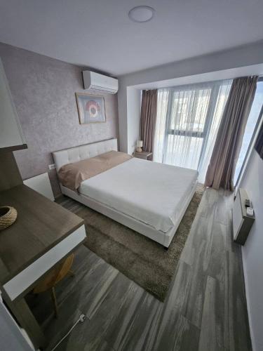a bedroom with a white bed and a large window at Sea View Apartments Olimp by Stela in Olimp