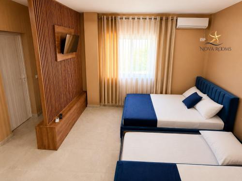 a hotel room with two beds and a window at Nova Rooms Velipojë in Velipojë