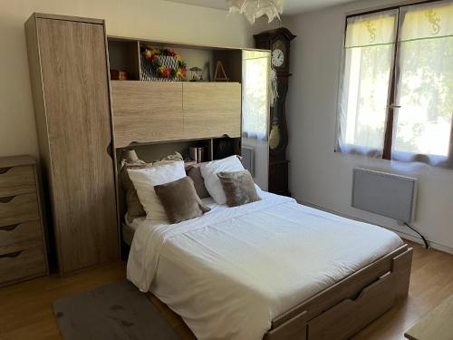 a bedroom with a large bed with white sheets and pillows at Maison Vexin in Boury-en-Vexin