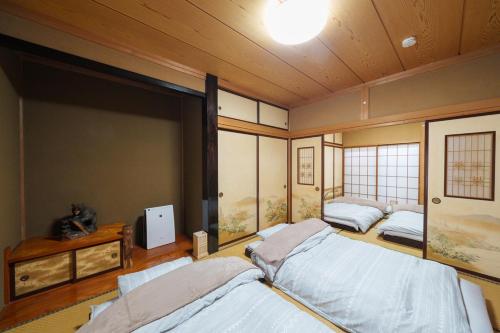 a bedroom with two beds and a large window at 民泊ａｉｋｏ in Fukushima