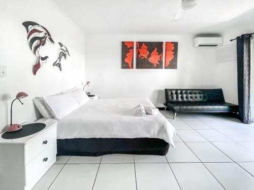 a white bedroom with a bed and a couch at DHR U120 - The Oceana in Eimeo