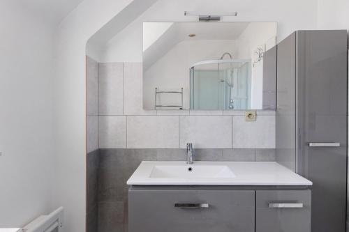 a white bathroom with a sink and a mirror at Le Vallon in Mondion