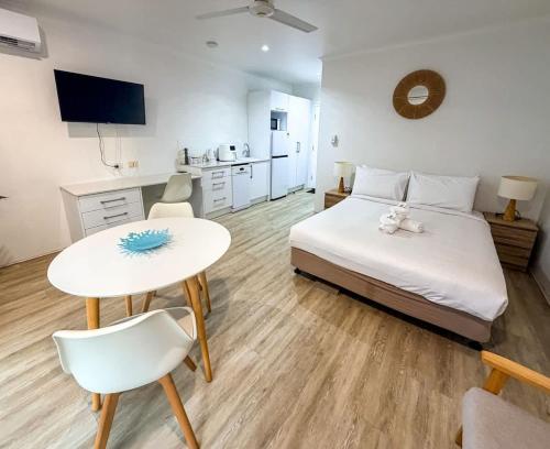 a bedroom with a bed and a table and a kitchen at U222 - The Serenity in Eimeo
