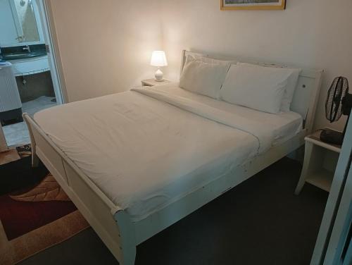 a bed with white sheets and pillows in a room at Imperial resident time Square KL in Kuala Lumpur