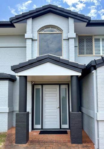 a white house with a door and a window at Belle Vue - 4brm 2bth AC Pool Views in Eimeo