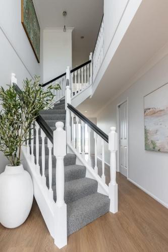 a white staircase in a home with a vase at Belle Vue - 4brm 2bth AC Pool Views in Eimeo