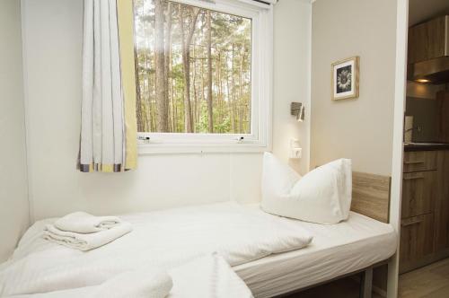 a bedroom with a bed and a window at Tiny Chalet Nr 815 in Göhren