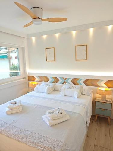 a bedroom with a large white bed with towels on it at Luxury White Summer Benalmadena in Benalmádena