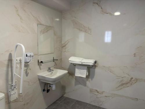 a white bathroom with a sink and a mirror at HOSTAL GOLDEN 21*** in Madrid