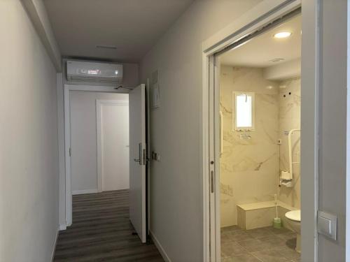 a bathroom with a shower and a toilet and a door at HOSTAL GOLDEN 21*** in Madrid