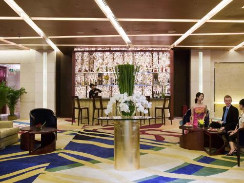 a lobby with a table with a vase of flowers at Grand Mercure Beijing Central in Beijing