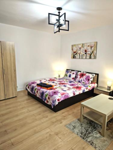 a bedroom with a bed and a chandelier at Gamma Group Sud in Bucharest
