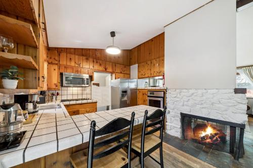 a kitchen with a fireplace in the middle of it at Cozy Pines & Paths Retreat in South Lake Tahoe