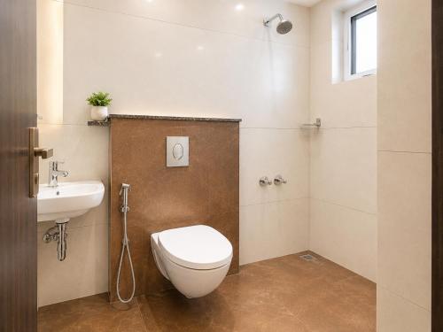 a bathroom with a toilet and a sink at Zenora Suites in Kozhikode