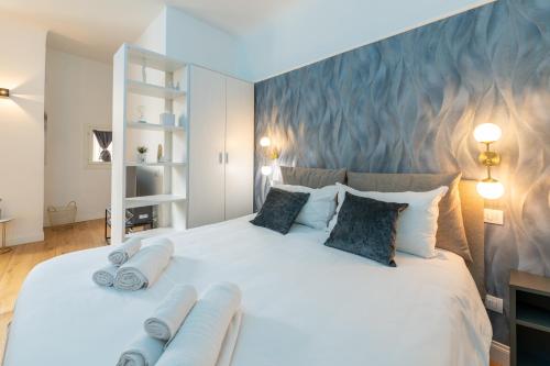 a bedroom with a large white bed with towels on it at BF Glam-Apartments in Perugia