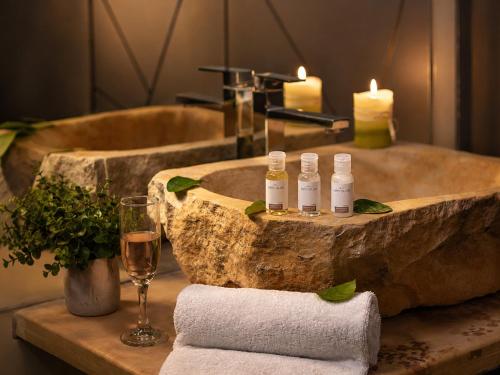 a bathroom with a stone tub with candles and a glass of wine at Zen Hotel Boutique in Bogotá