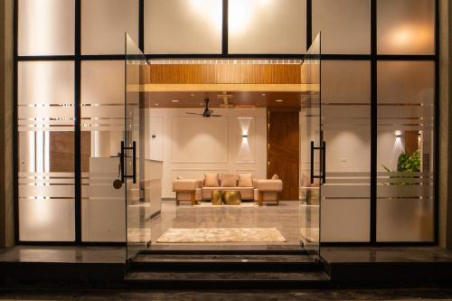 a glass door leading into a living room with a couch at Hill Turn Corbett in Rāmnagar