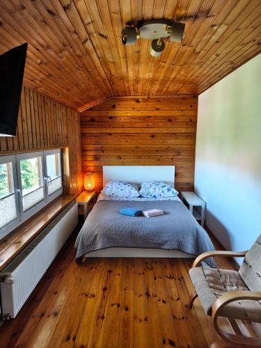 a bedroom with a bed and a wooden ceiling at Willa 2 piętro in Szczecinek