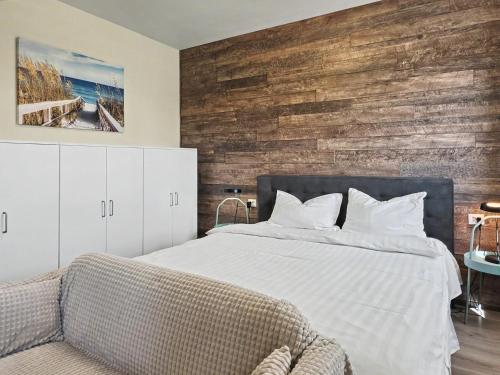 a bedroom with a bed and a wooden wall at Konstanzer 95 - Cozy Studio - Iulius Mall - AC in Iaşi