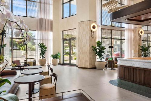 a lobby with tables and chairs and windows at Domus Brickell Park in Miami