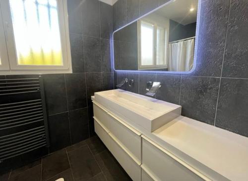 a bathroom with a white sink and a mirror at Maison familiale dans le var in Brignoles