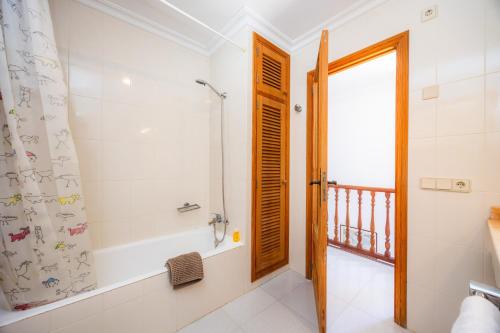 a bathroom with a shower and a tub and a window at Can Figó in Alcudia