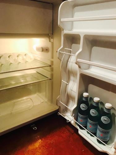 an open refrigerator with bottles of water in it at Studio H St Corridor in Washington, D.C.