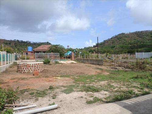 a dirt yard with a building in the background at Basant - Madhu in Alibaug