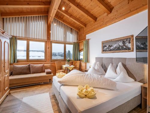 a bedroom with a large bed and a couch at Hotel Theresia Garni in Sankt Johann in Tirol