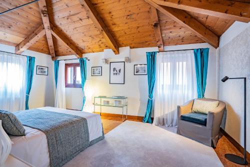 a bedroom with a bed and a chair at Ca' Del Monastero 9 Collection Spacious Apartment up to 5 Guests in Venice