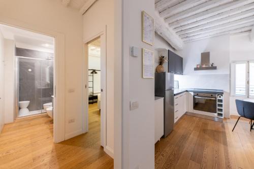 a kitchen with white walls and a wooden floor at BF Glam-Apartments in Perugia