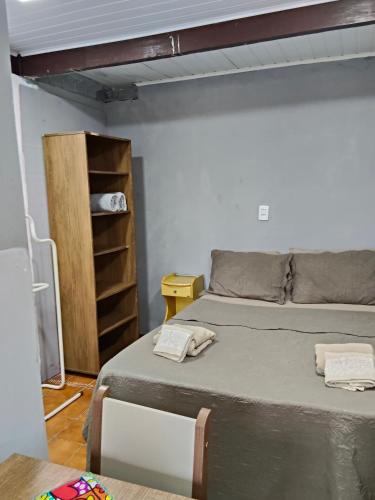 a bedroom with a bed and a book shelf at Espaçoso para casais in Vila Velha