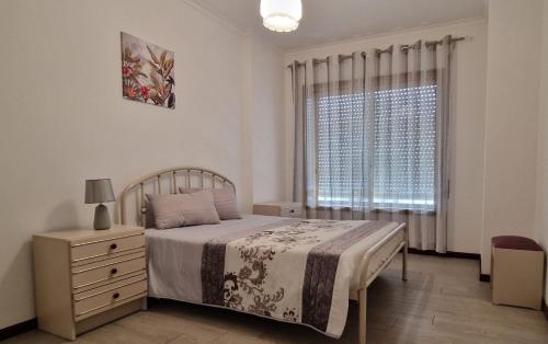 a bedroom with a bed with a dresser and a window at Terra e Mar in Amorosa