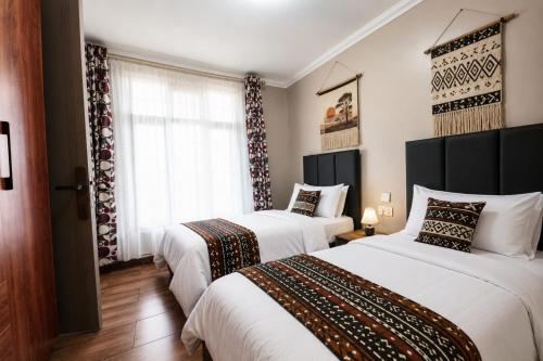 two beds in a hotel room with white sheets at Shamba la Chini in Nairobi