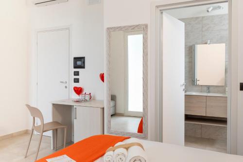 a bedroom with a mirror and a desk and a bed at Almària - Rooms e Garden in Nardò