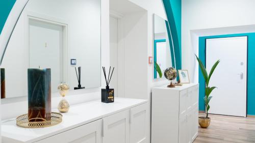 a room with white cabinets and mirrors and vases at Harmonia Rooms by Italy Home Experience in Civitavecchia