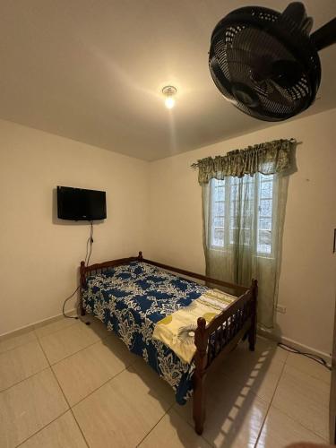 a bedroom with a bed and a flat screen tv at Cuartos amoblados arraijan in Palo Diferente