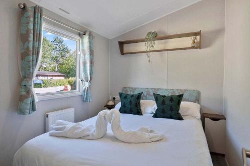 a bedroom with a bed with white sheets and a window at Lovely 3 bedroom holiday home in Seton Sand caravan park Wi-Fi Xbox in Edinburgh