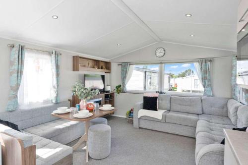 a living room with a couch and a table at Lovely 3 bedroom holiday home in Seton Sand caravan park Wi-Fi Xbox in Edinburgh