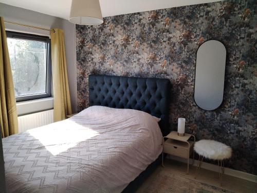 a bedroom with a bed and two mirrors on the wall at Willow House in Newtownshandrum
