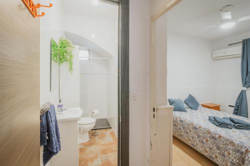 a small bedroom with a bed and a bathroom at Pisito del Pueblo in Navaluenga
