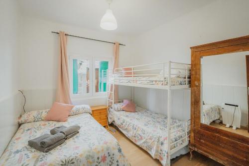 a bedroom with two bunk beds and a mirror at Pisito del Pueblo in Navaluenga