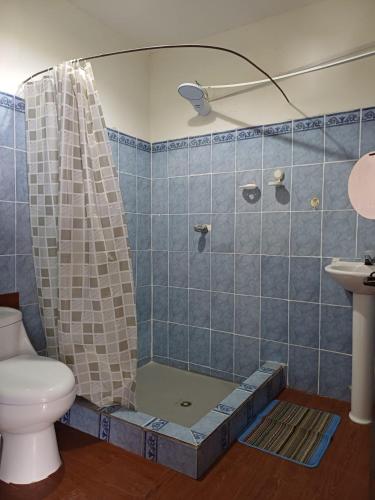 a bathroom with a shower with a toilet and a sink at Hotel casa de doña Rome in Chichicastenango