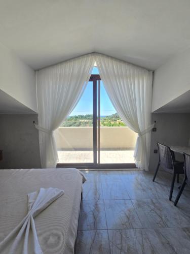 a bedroom with a bed and a large window at Olive Tree Apart Hotel in Muğla
